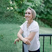 Kasia outside looking off to the left leaning on rail